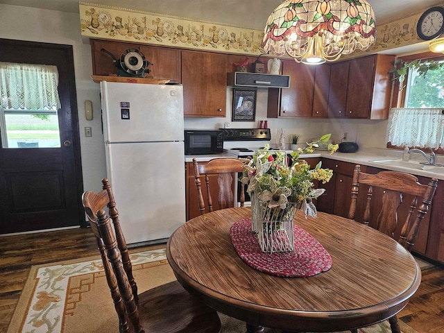 7310 Old 57 Rd, Greenleaf, WI 54126 - kitchen with freestanding refrigerator, black microwave, light countertops, a sink, and a chandelier