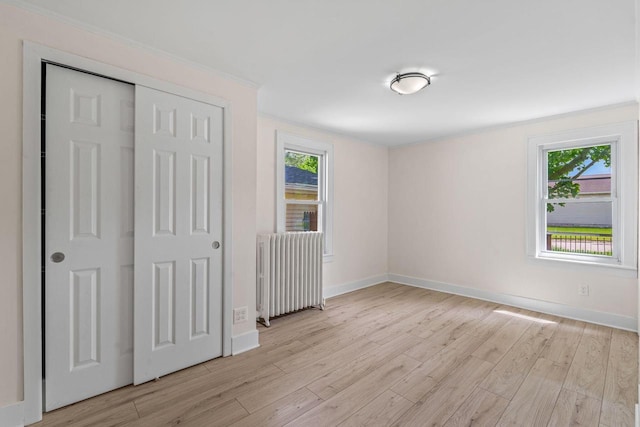 603 Spring St, Lake Geneva, WI 53147 - unfurnished bedroom featuring radiator, light wood-style flooring, and multiple windows