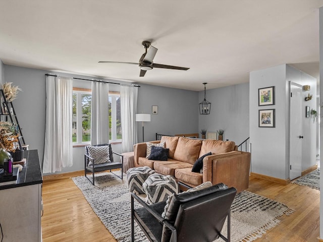 1801 S 24th St, Manitowoc, WI 54220 - living room featuring light wood finished floors, a ceiling fan, baseboards, and a chandelier