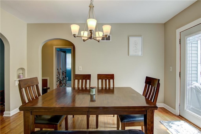1805 Main St, Eau Claire, WI 54701 - dining room featuring a chandelier, light wood-type flooring, arched walkways, and baseboards