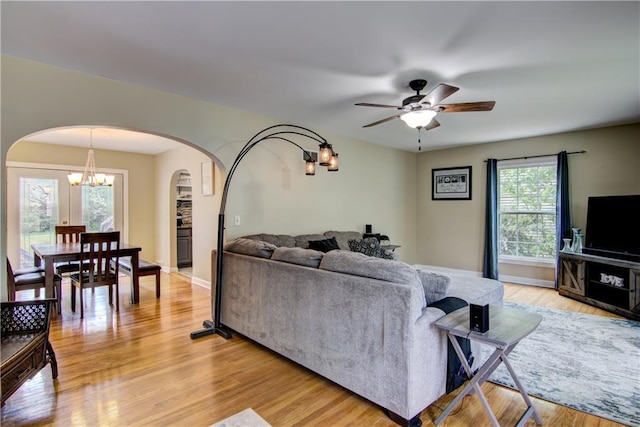 1805 Main St, Eau Claire, WI 54701 - living area with arched walkways, light wood-style floors, a chandelier, a ceiling fan, and baseboards