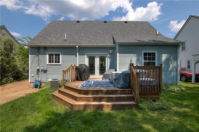 1805 Main St, Eau Claire, WI 54701 - rear view of house featuring french doors, a lawn, a wooden deck, a shingled roof, and central AC