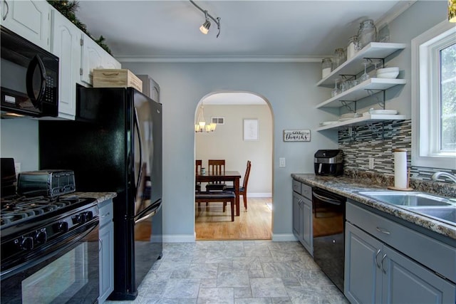 1805 Main St, Eau Claire, WI 54701 - kitchen with black appliances, arched walkways, a sink, baseboards, and white cabinets