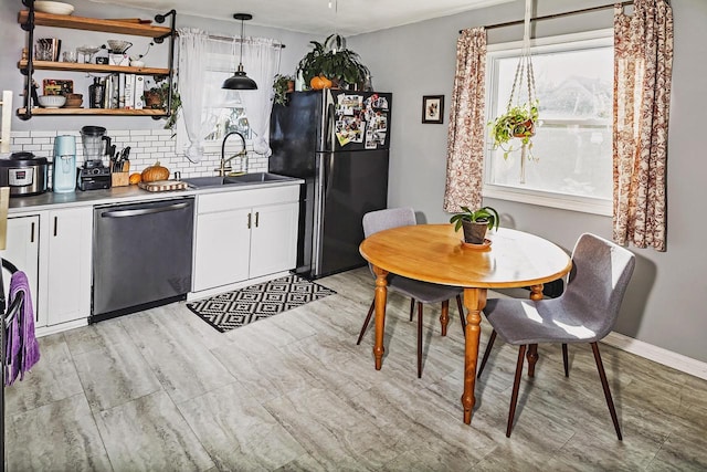 3162 S Austin St, Milwaukee, WI 53207 - kitchen featuring stainless steel dishwasher, a sink, freestanding refrigerator, decorative backsplash, and white cabinets