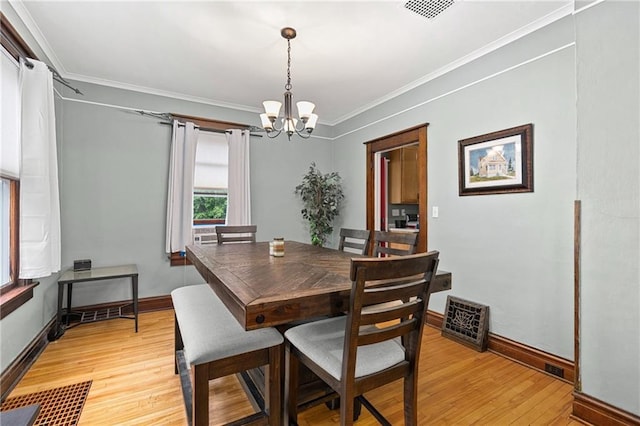 1528 Bellevue Ave, Eau Claire, WI 54703 - dining room featuring a chandelier, light wood finished floors, crown molding, and baseboards