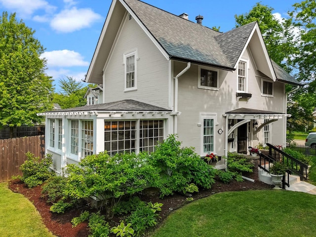 234 Warren St, Lake Geneva, WI 53147 - rear view of house with roof with shingles, a sunroom, and a chimney