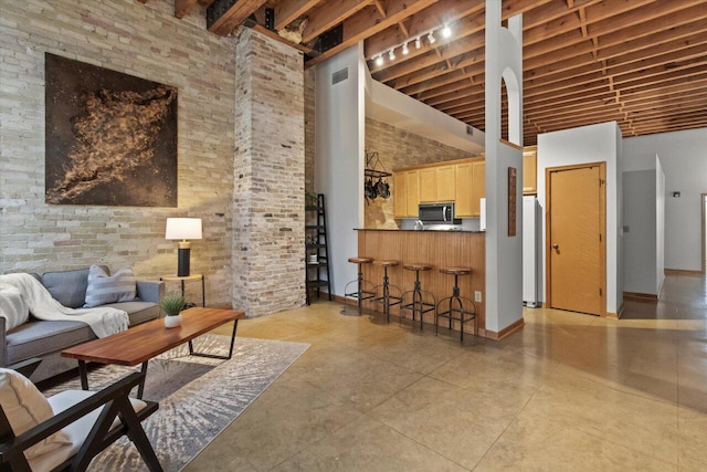771 N Water St Unit 25, Milwaukee, WI 53202 - living area featuring a high ceiling, beam ceiling, and baseboards