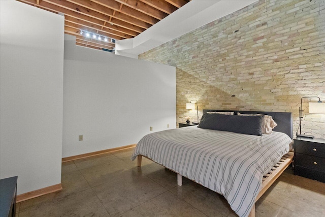 771 N Water St Unit 25, Milwaukee, WI 53202 - bedroom featuring baseboards, a high ceiling, and brick wall