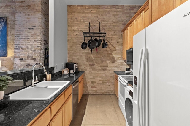771 N Water St Unit 25, Milwaukee, WI 53202 - kitchen with white appliances, brick wall, a sink, dark countertops, and light tile patterned flooring