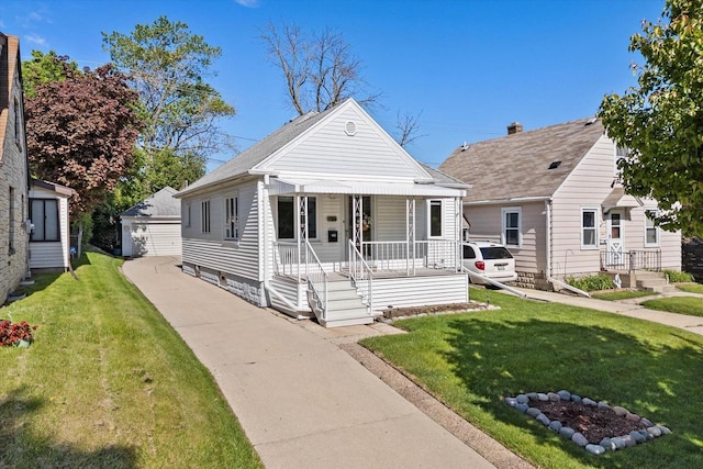 2147 S 90th St, West Allis, WI 53227 - view of front of property with covered porch, a front yard, and a detached garage