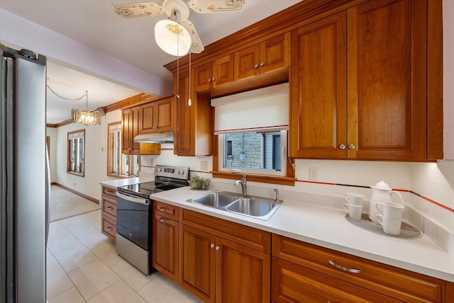 2147 S 90th St, West Allis, WI 53227 - kitchen featuring stainless steel appliances, a sink, under cabinet range hood, brown cabinetry, and light countertops