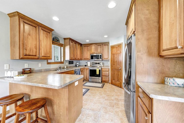 3611 Glen Kent Ct, Green Bay, WI 54313 - kitchen featuring stainless steel appliances, a peninsula, a breakfast bar, recessed lighting, and light countertops