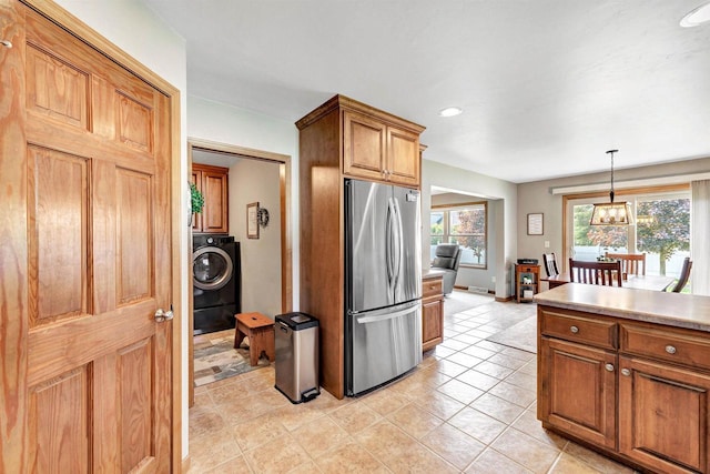 3611 Glen Kent Ct, Green Bay, WI 54313 - kitchen featuring freestanding refrigerator, washer / dryer, brown cabinetry, decorative light fixtures, and light countertops