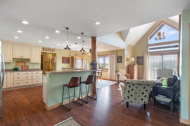 N8092 15th Ave, New Lisbon, WI 53950 - kitchen featuring open floor plan, cream cabinetry, dark wood finished floors, a breakfast bar area, and recessed lighting