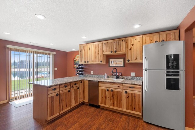 N8092 15th Ave, New Lisbon, WI 53950 - kitchen with freestanding refrigerator, stainless steel dishwasher, a sink, a peninsula, and dark wood finished floors