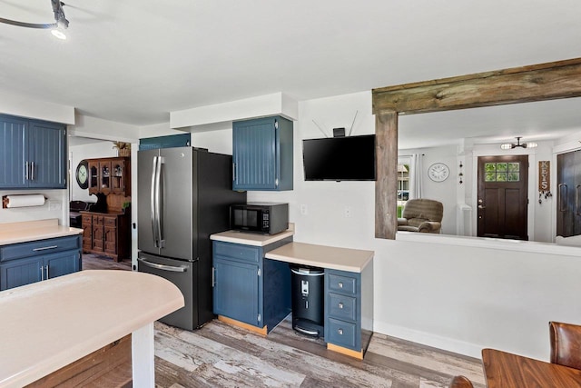 2127 Jen Rae Rd, Green Bay, WI 54311 - kitchen featuring blue cabinetry, black microwave, and freestanding refrigerator