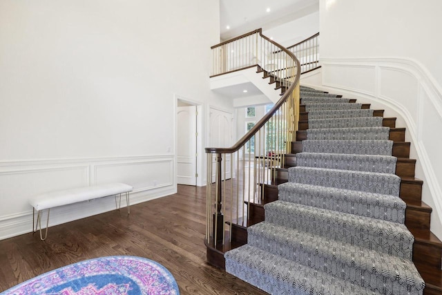 10031 N Range Line Rd, Mequon, WI 53092 - staircase featuring wood finished floors, a decorative wall, a wainscoted wall, and a high ceiling