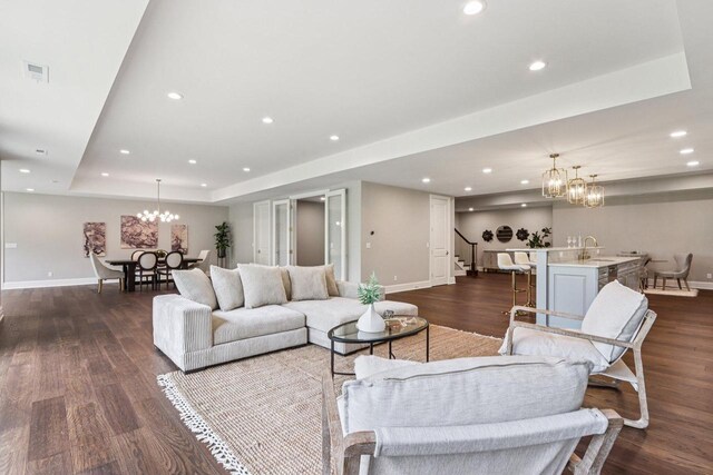 10031 N Range Line Rd, Mequon, WI 53092 - living room featuring a chandelier, stairway, a raised ceiling, dark wood-style flooring, and recessed lighting