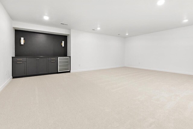 2590 N Stellita Cir, De Pere, WI 54115 - unfurnished living room featuring light carpet, recessed lighting, wine cooler, and baseboards