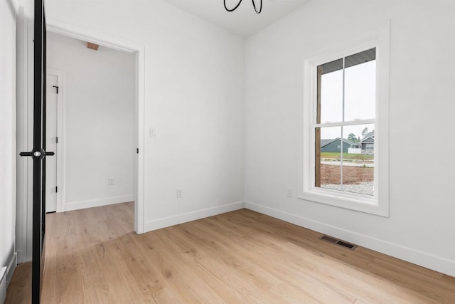 2590 N Stellita Cir, De Pere, WI 54115 - unfurnished room with light wood finished floors, baseboards, and a chandelier