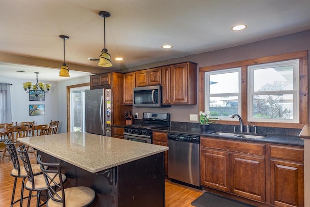 2946 Shadow Ln, Oshkosh, WI 54901 - kitchen featuring stainless steel appliances, a sink, light wood finished floors, a kitchen breakfast bar, and a center island
