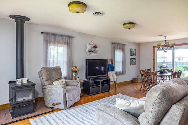 2946 Shadow Ln, Oshkosh, WI 54901 - living room featuring a wood stove, plenty of natural light, a chandelier, and baseboards