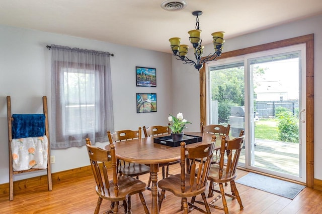 2946 Shadow Ln, Oshkosh, WI 54901 - dining room featuring light wood-style flooring, a chandelier, and baseboards