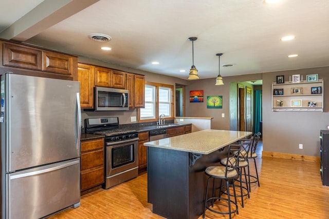 2946 Shadow Ln, Oshkosh, WI 54901 - kitchen with stainless steel appliances, a sink, light wood-style flooring, a center island, and recessed lighting