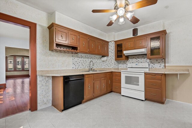 8511 W Orchard St, West Allis, WI 53214 - kitchen featuring black dishwasher, white electric range oven, under cabinet range hood, a sink, and brown cabinetry