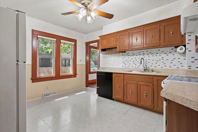 8511 W Orchard St, West Allis, WI 53214 - kitchen featuring a sink, stainless steel refrigerator, dishwasher, brown cabinetry, and light countertops