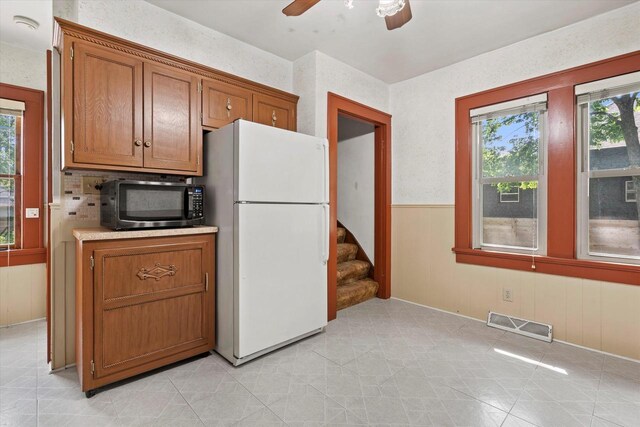 8511 W Orchard St, West Allis, WI 53214 - kitchen featuring freestanding refrigerator, black microwave, a ceiling fan, brown cabinets, and light countertops