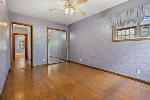 8511 W Orchard St, West Allis, WI 53214 - unfurnished bedroom with hardwood / wood-style floors, baseboards, a closet, and a ceiling fan