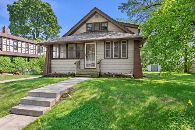 8511 W Orchard St, West Allis, WI 53214 - bungalow with a front yard, a sunroom, and a shingled roof