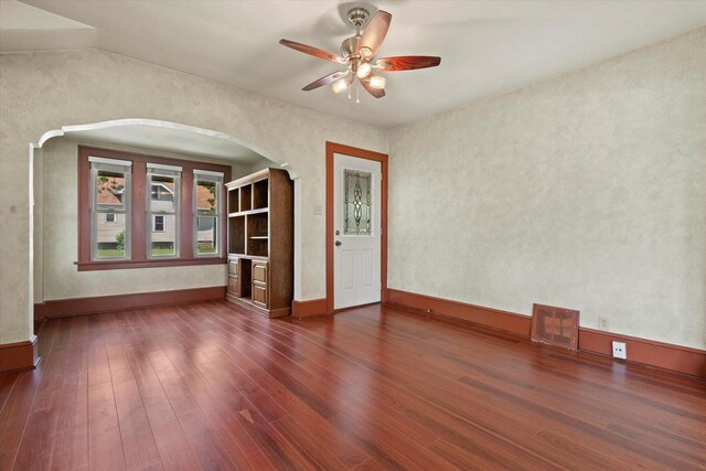 8511 W Orchard St, West Allis, WI 53214 - spare room with arched walkways, dark wood-style floors, a ceiling fan, and baseboards