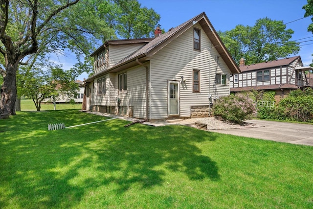 8511 W Orchard St, West Allis, WI 53214 - rear view of property with a chimney and a lawn