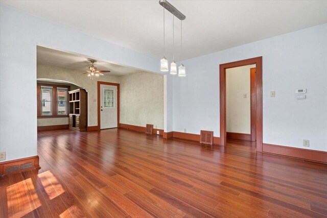 8511 W Orchard St, West Allis, WI 53214 - empty room with arched walkways, wood finished floors, baseboards, and a ceiling fan