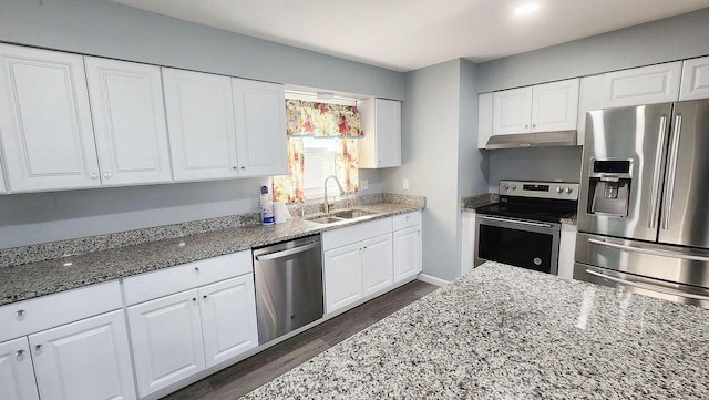 9085 N Joyce Ave, Milwaukee, WI 53224 - kitchen featuring appliances with stainless steel finishes, under cabinet range hood, a sink, light stone countertops, and dark wood-type flooring