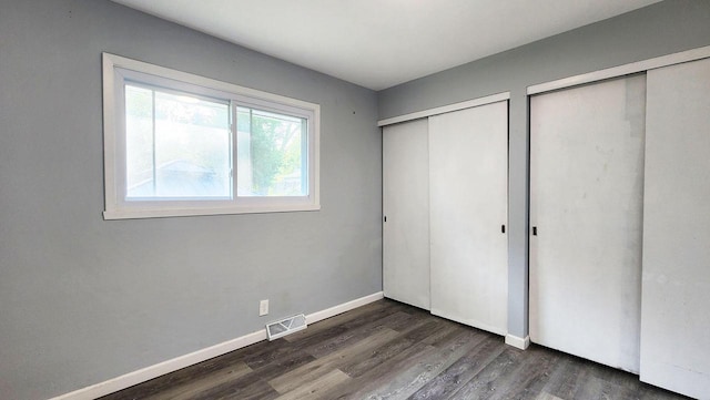 9085 N Joyce Ave, Milwaukee, WI 53224 - unfurnished bedroom featuring two closets, wood finished floors, and baseboards