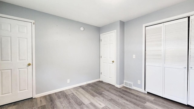 9085 N Joyce Ave, Milwaukee, WI 53224 - unfurnished bedroom featuring wood finished floors, a closet, and baseboards