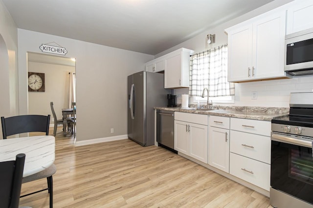 1614 N Richmond St, Appleton, WI 54911 - kitchen featuring stainless steel appliances, a sink, light wood-style floors, white cabinetry, and baseboards
