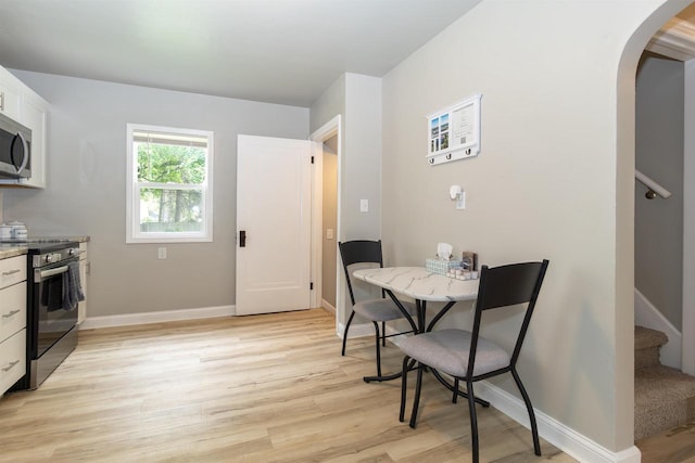 1614 N Richmond St, Appleton, WI 54911 - dining space with arched walkways, stairway, light wood-style floors, and baseboards