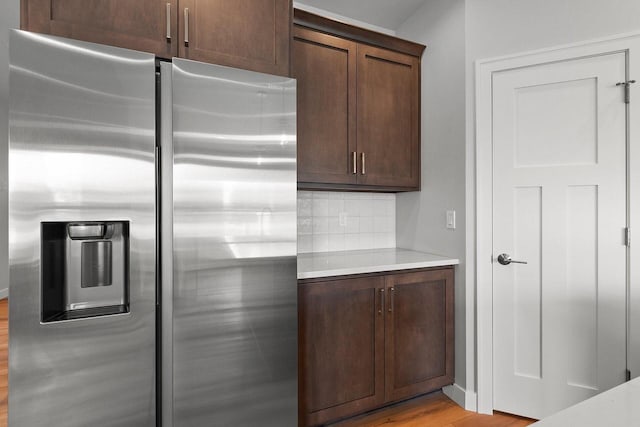 1925 Creekwood Ct, Manitowoc, WI 54220 - kitchen featuring stainless steel refrigerator with ice dispenser, light countertops, tasteful backsplash, and light wood-style flooring