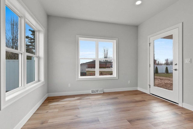 1925 Creekwood Ct, Manitowoc, WI 54220 - empty room with healthy amount of natural light, recessed lighting, light wood finished floors, and baseboards