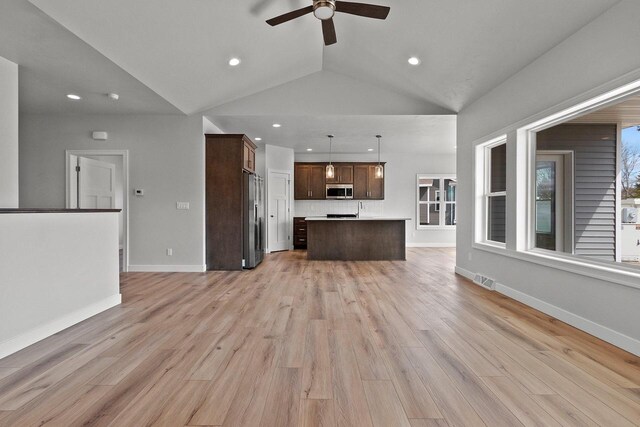 1925 Creekwood Ct, Manitowoc, WI 54220 - unfurnished living room featuring a ceiling fan, vaulted ceiling, light wood-style floors, recessed lighting, and baseboards
