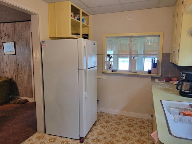 N9221 Sumac Ln, Gresham, WI 54128 - kitchen featuring freestanding refrigerator, baseboards, wooden walls, light countertops, and decorative backsplash