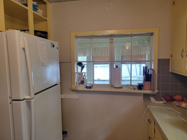 N9221 Sumac Ln, Gresham, WI 54128 - kitchen featuring freestanding refrigerator, healthy amount of natural light, and backsplash