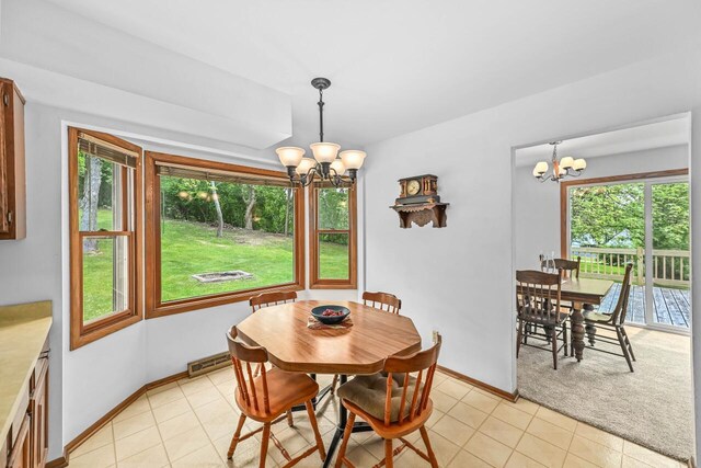 S25W27040 Winnebago Way, Waukesha, WI 53188 - dining space featuring a chandelier, light tile patterned floors, baseboards, and light colored carpet