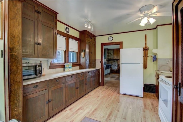 17174 59th Ave, Chippewa Falls, WI 54729 - kitchen featuring white appliances, a sink, ceiling fan, light wood-style floors, and light countertops