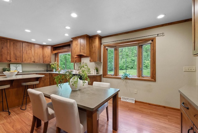 W188N10115 Maple Rd, Germantown, WI 53022 - kitchen with brown cabinets, recessed lighting, light wood-type flooring, and a kitchen bar