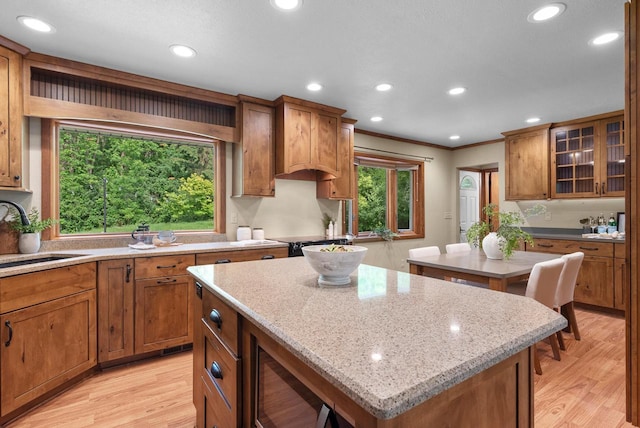 W188N10115 Maple Rd, Germantown, WI 53022 - kitchen featuring a center island, light wood-style floors, ornamental molding, brown cabinets, and recessed lighting